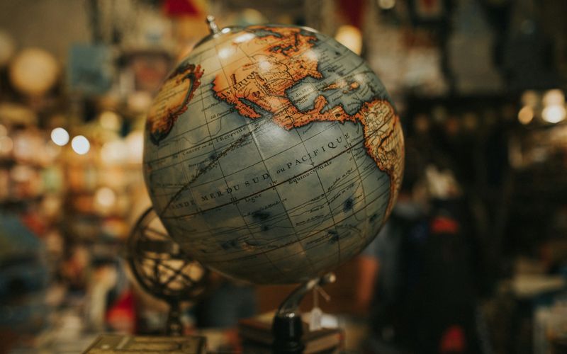 Decorative globe beside stacked books against a softly blurred interior.